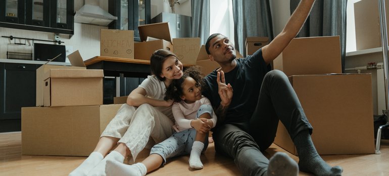 A family taking selfies during their stress-free move while residential movers Staten Island are at work.