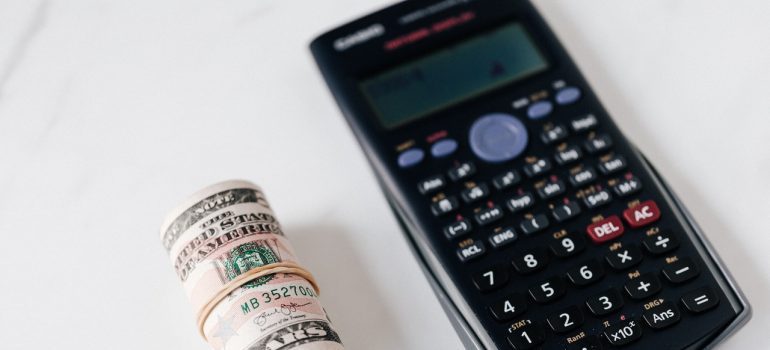 Rolled-up money next to a calculator.