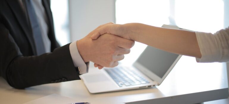 An emplyee and a client shaking hands.