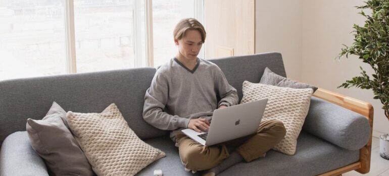 A man looking to hire Gramercy movers on his laptop.