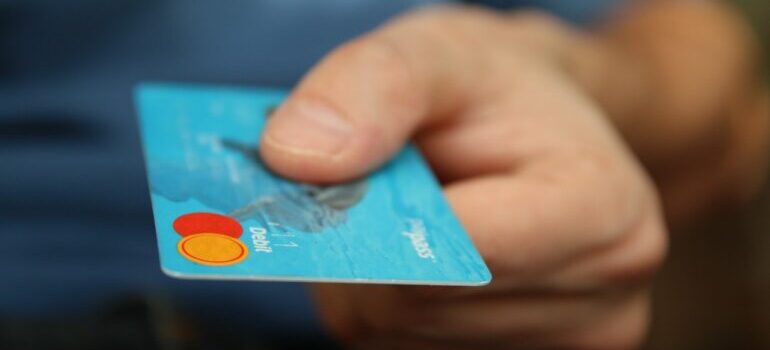 A hand holding a blue debit card. 