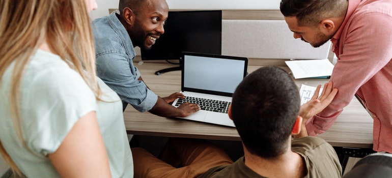 People in a meeting looking at a laptop screen, before hiring the best Caroll Garden movers.