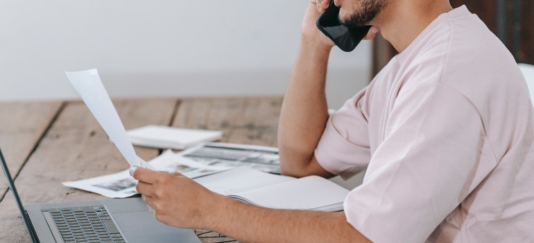 A man is looking at a list while sitting at a desk.