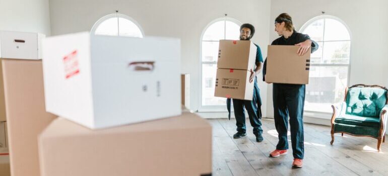 Two movers carrying boxes