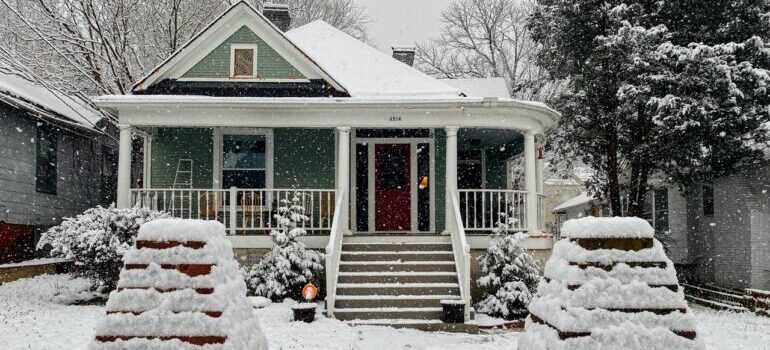 House and front yard covered in snow.
