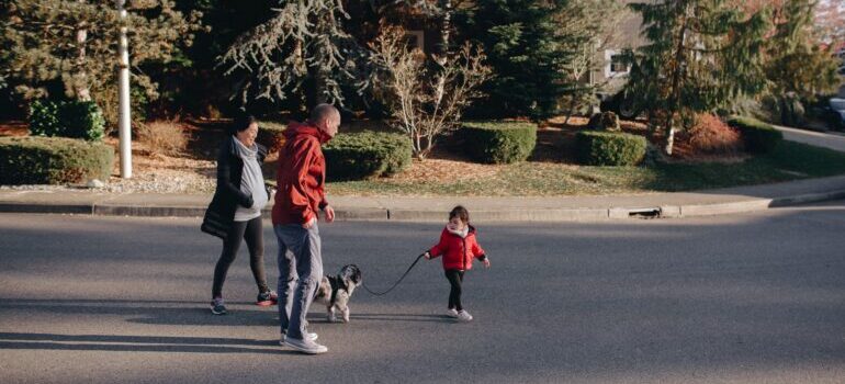 A family walking the dog after moving from NYC to a small town.