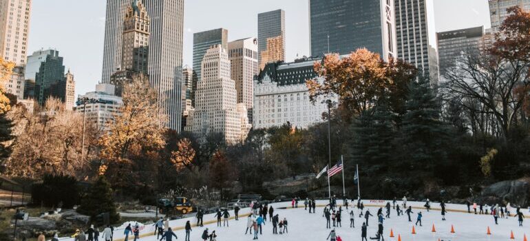 People are skating at the foot of big buildings in New York