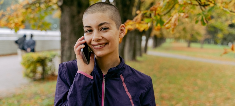 happy woman taking about moving from NY to North Carolina on a phone