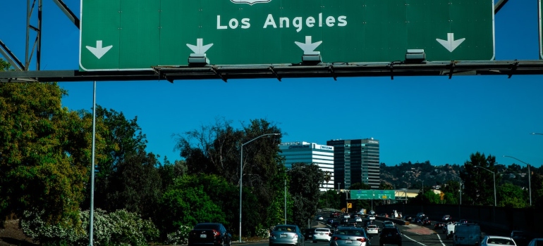 an entrance to Los Angeles with large rows of traffic on the road to represent on of the challenges of moving from NYC to LA